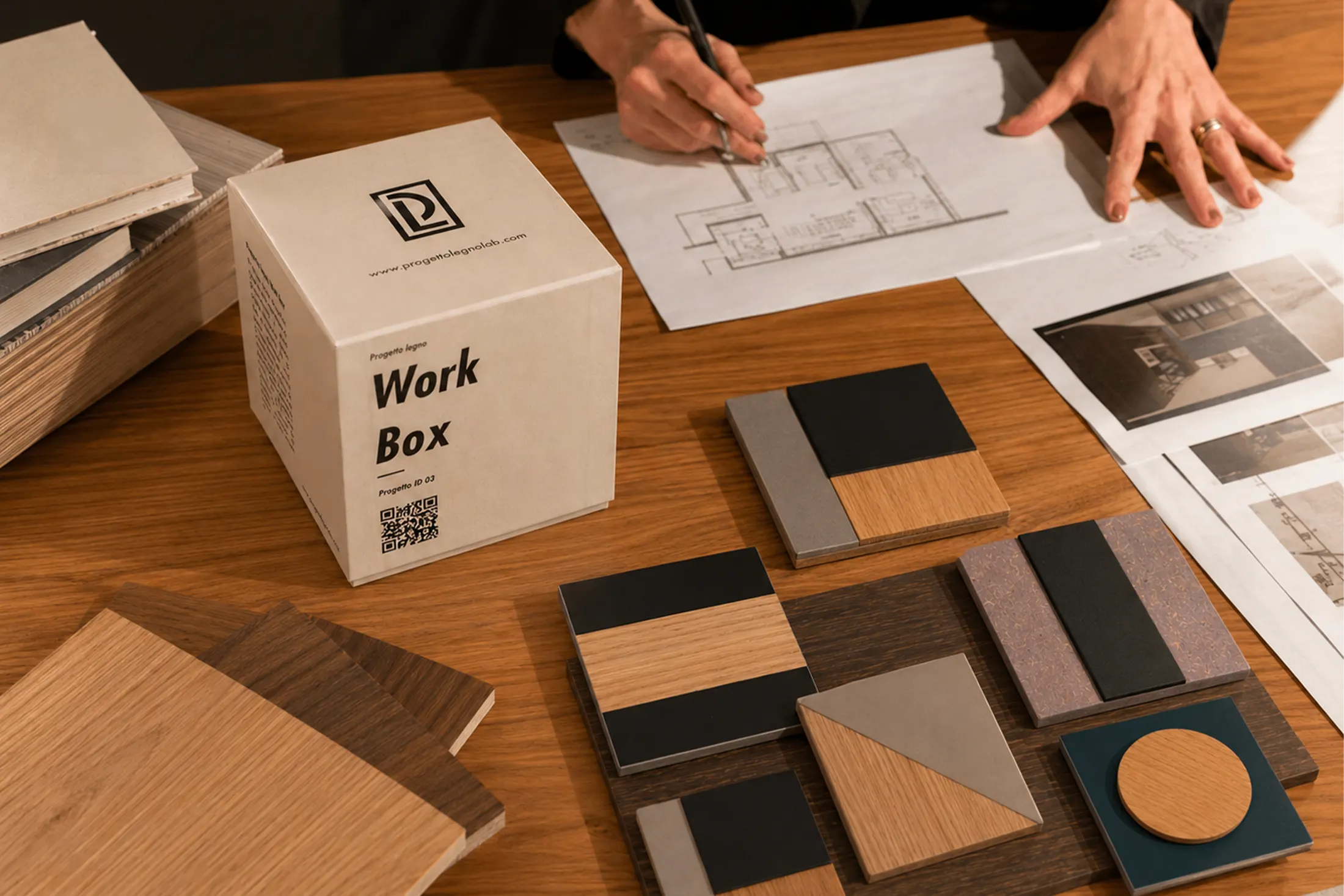 Work Box con campioni di legno e finiture accanto a un disegno di progetto