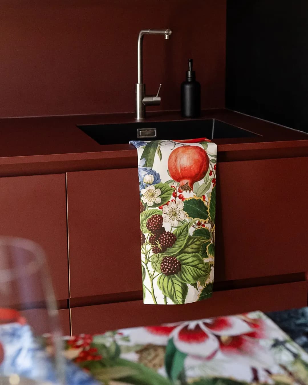 Strofinaccio a stampa di frutti di bosco in una cucina rosso mattone