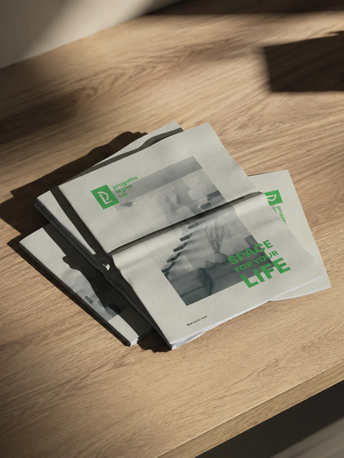 Copies of the catalogue stacked on a wooden table