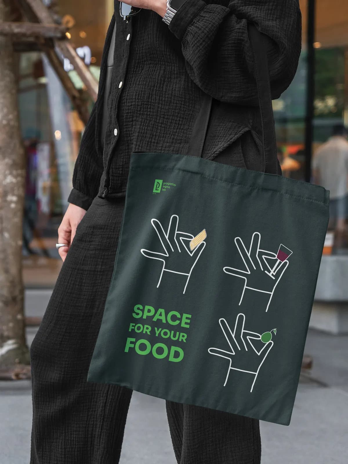 Green tote bag with illustration and the line Space for your food, worn
