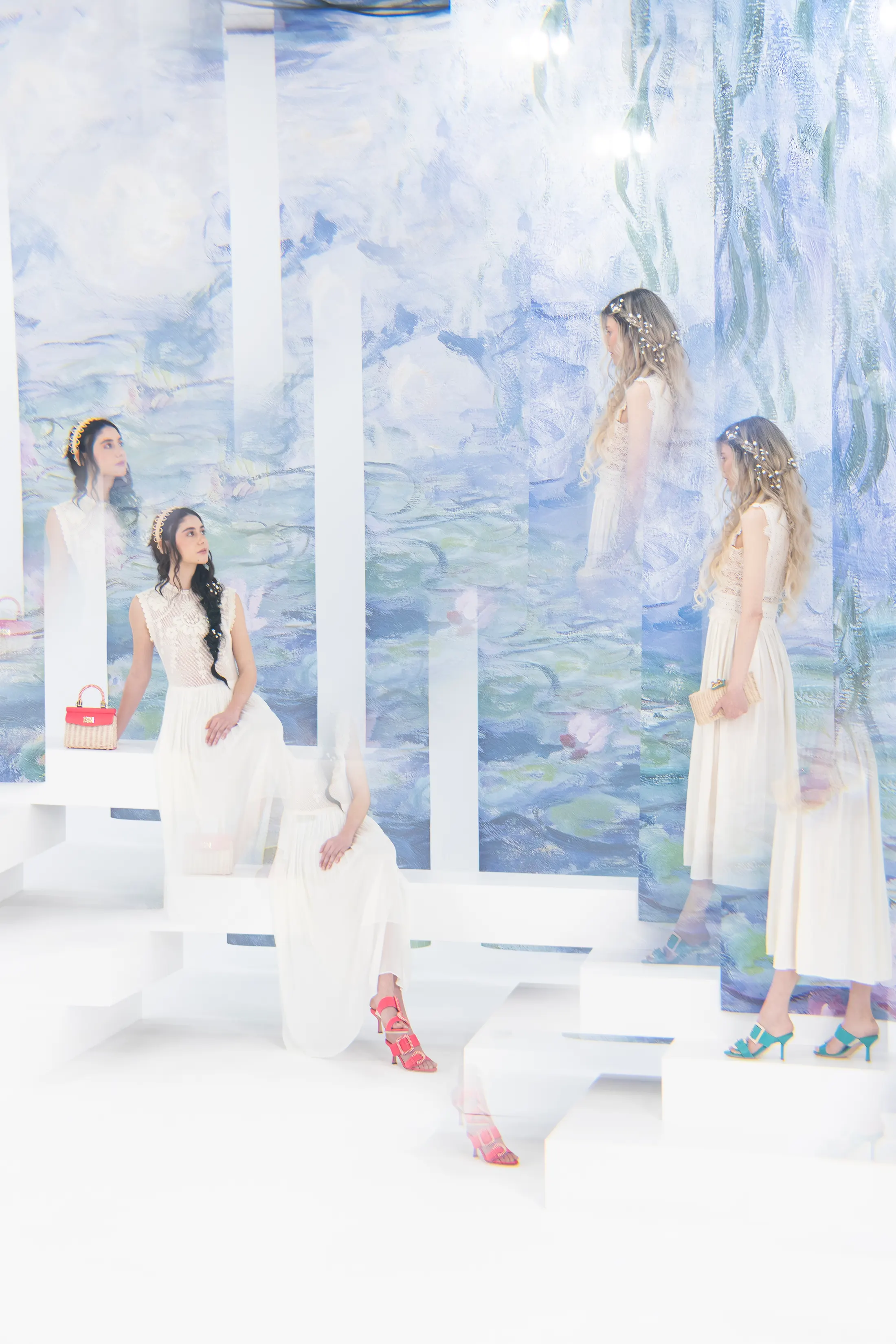 Photographic set with white plinths in front of the water lilies backdrop, two models in pale dresses