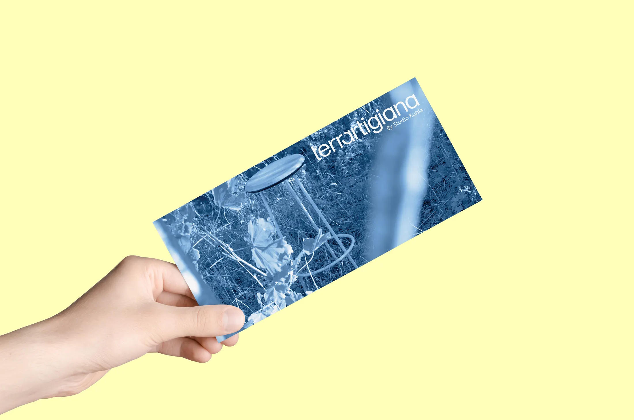 Hand holding a brand card on a yellow ground