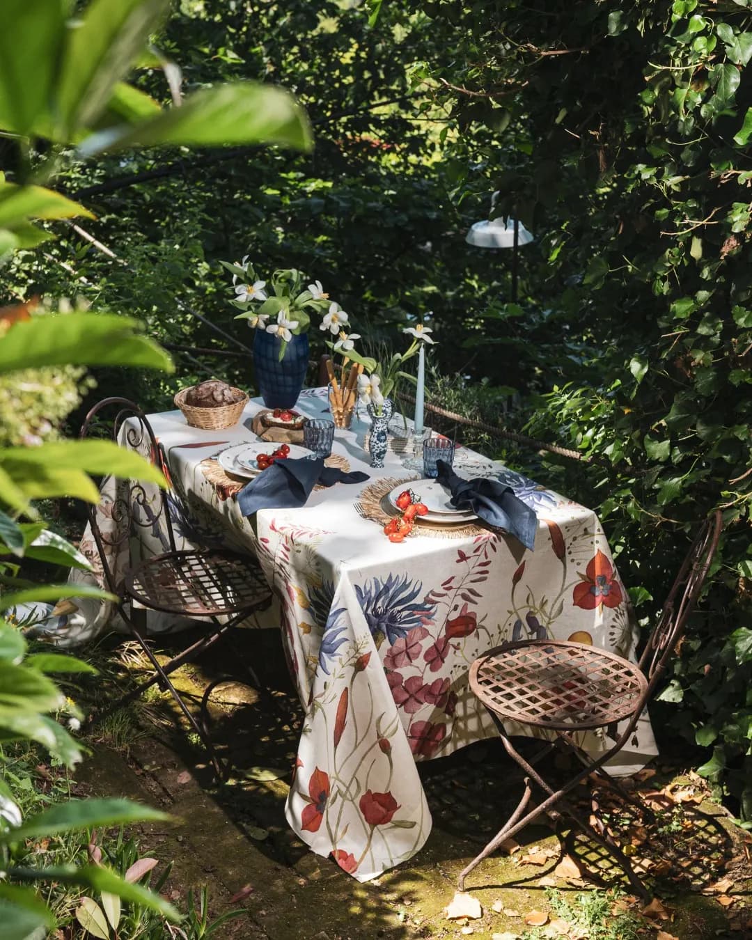 Table laid in the garden under the foliage, botanical print linen tablecloth