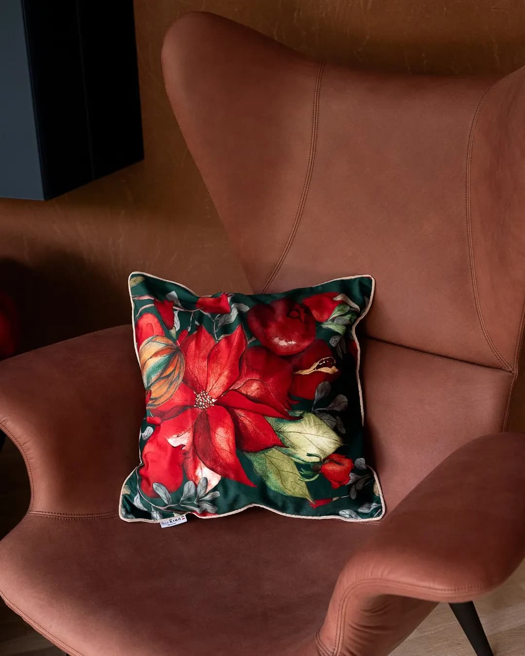 Linen cushion with red poinsettias on a pink armchair