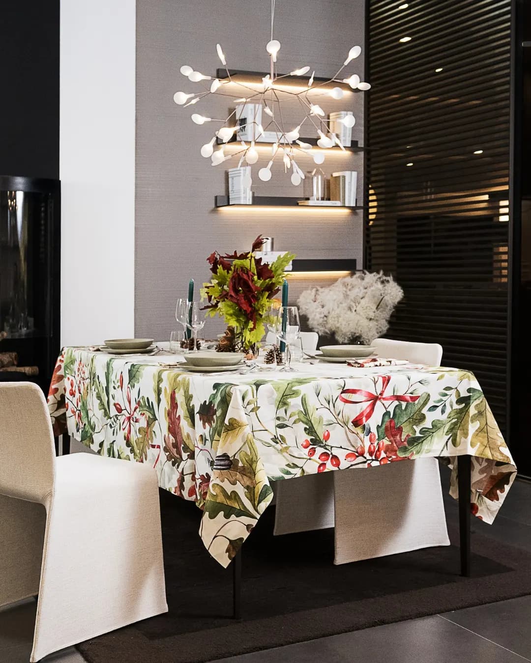 Table laid in a showroom, botanical tablecloth and chandelier