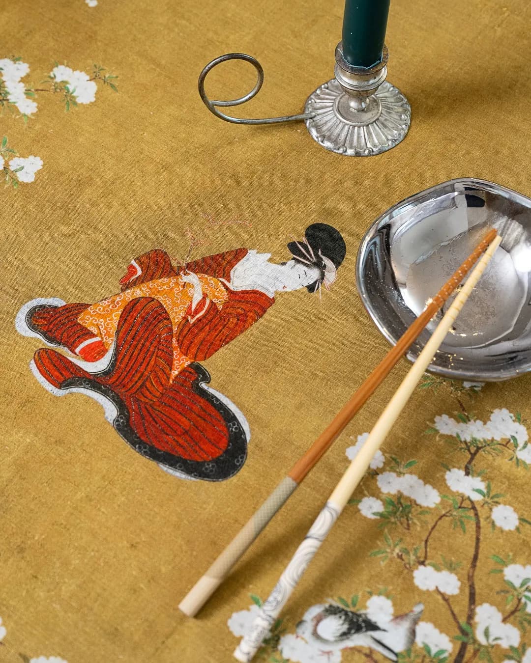 Yellow cloth with an embroidered fox, candlestick and cutlery from above