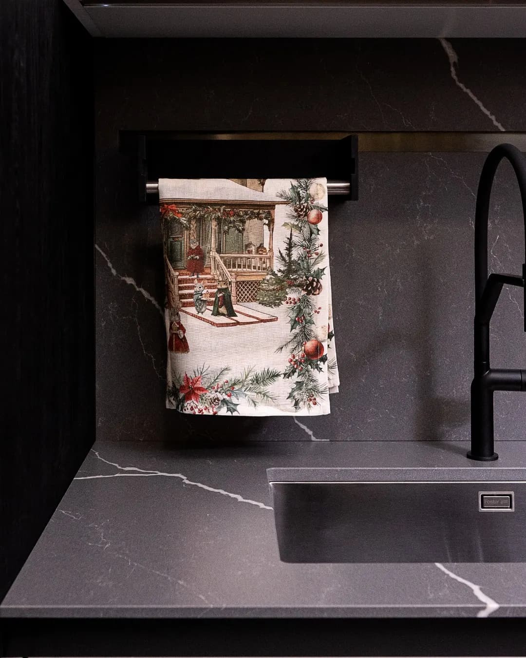 Winter-print kitchen towel hanging in a dark marble kitchen
