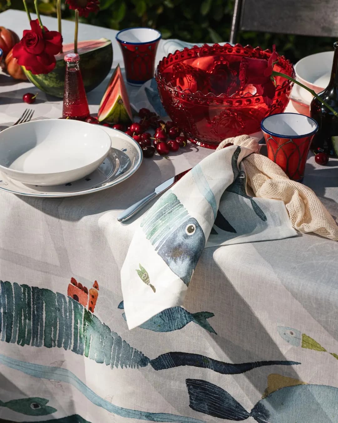 Christmas table setting in red with a fish-print napkin