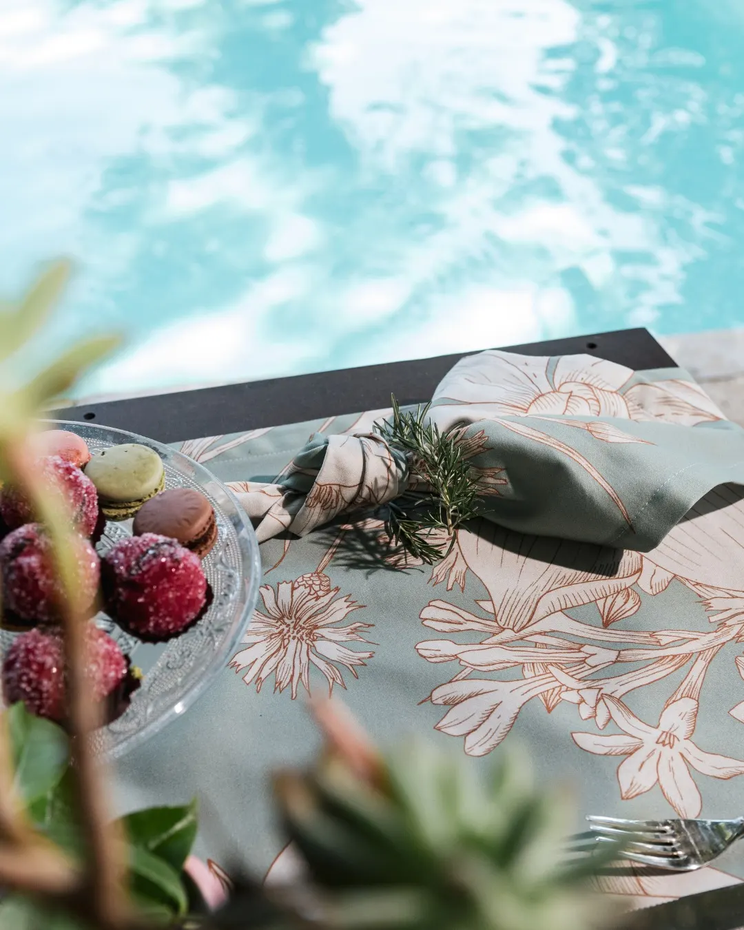 Floral cloth laid beside the pool, reflections in the water