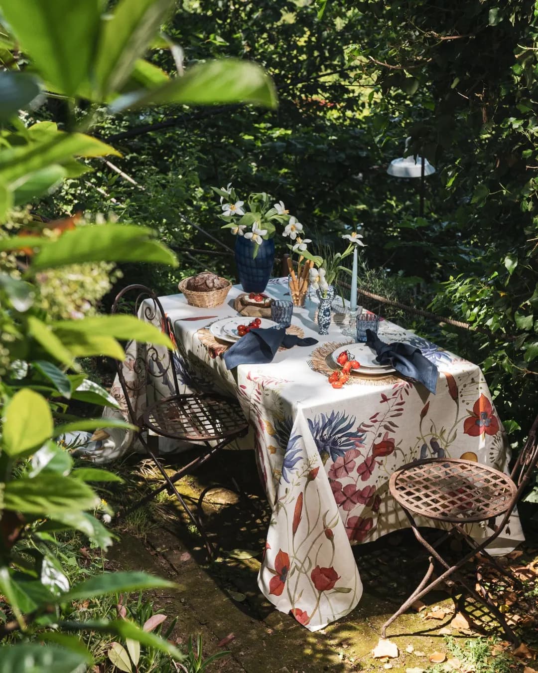 Table in the greenery seen from above, botanical cloth and baskets