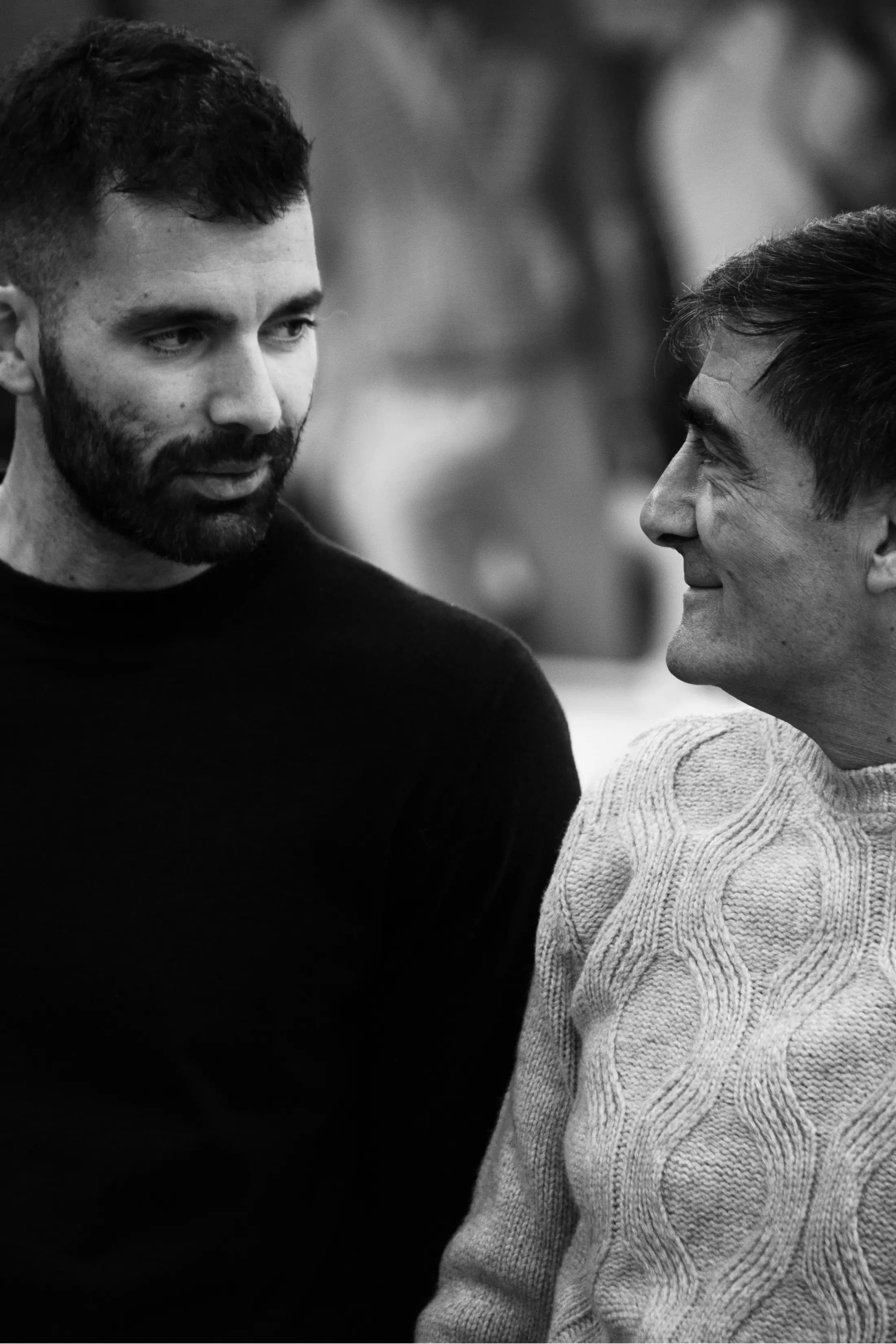 Two men of different generations facing each other, black and white portrait